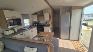 Eine kleine Küchenzeile mit Mikrowelle, Herd und Kühlschrank.