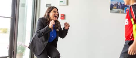 A person in a business suit running towards a door with a poster on the wall.