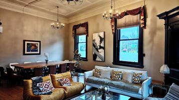 Un salon comprenant un canapé, des fauteuils, une table basse et un coin repas avec une table et des chaises.