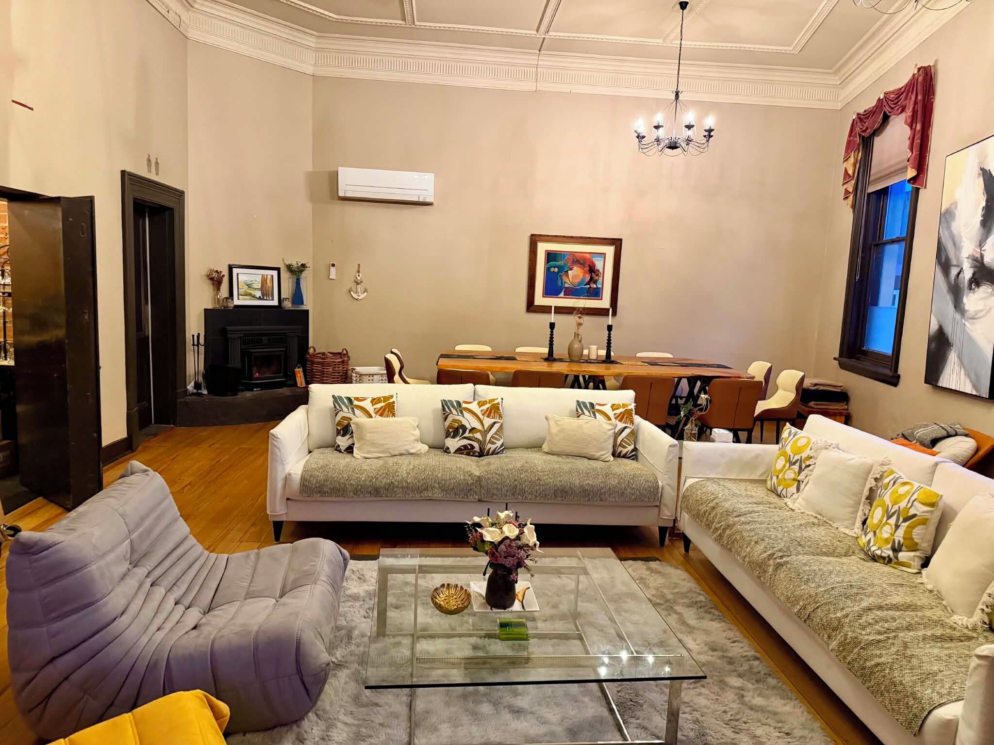 Una sala de estar con chimenea, comedor y candelabro.