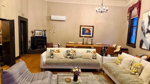 A living room with a fireplace, a dining area, and a chandelier. - The historical Bank house 2 (Lawrence)