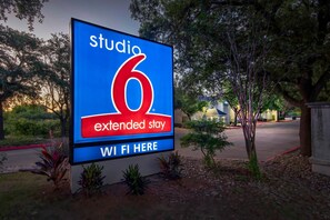 A sign for a studio 6 extended stay hotel with a Wi-Fi symbol. - 1 Queen Bed | Non-Smoking (Austin)