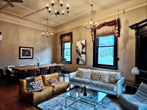 A living room with a sofa, armchairs, a coffee table, and a dining area with a table and chairs.