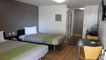 Een hotelkamer met twee bedden, een bureau, een stoel en een televisie.