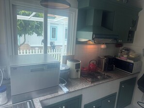 A kitchen with a built-in oven, a kettle, a microwave, and a coffee maker. - The Oasis Pool Villa (Chiang Mai)