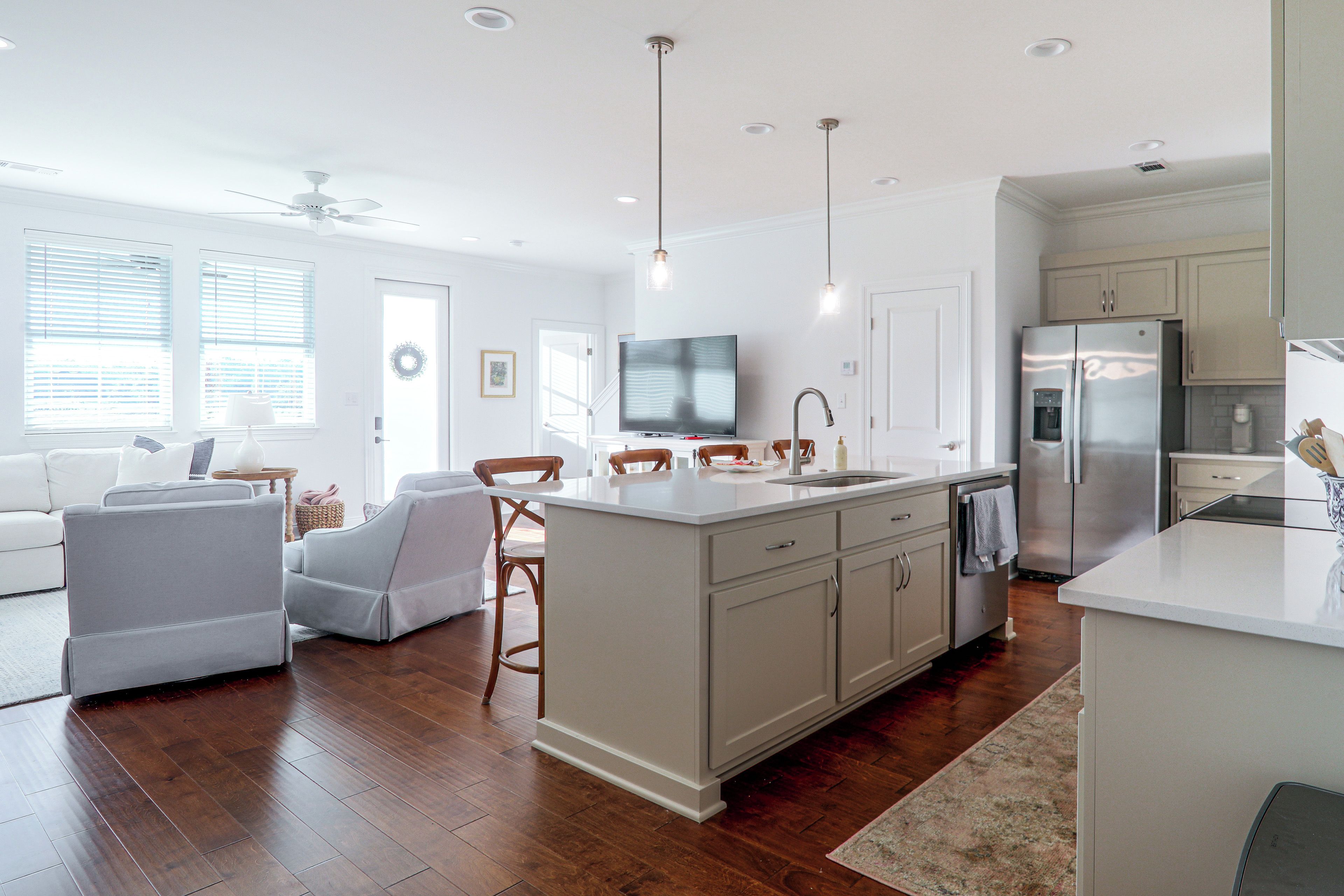 A modern kitchen with a central island, built-in appliances, and a dining area with a TV.