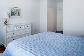 Ein Schlafzimmer mit Bett, Schminktisch und einem Bild an der Wand.
