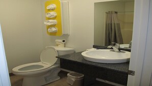 Ein kleines Badezimmer mit Toilette, Waschbecken und Spiegel.