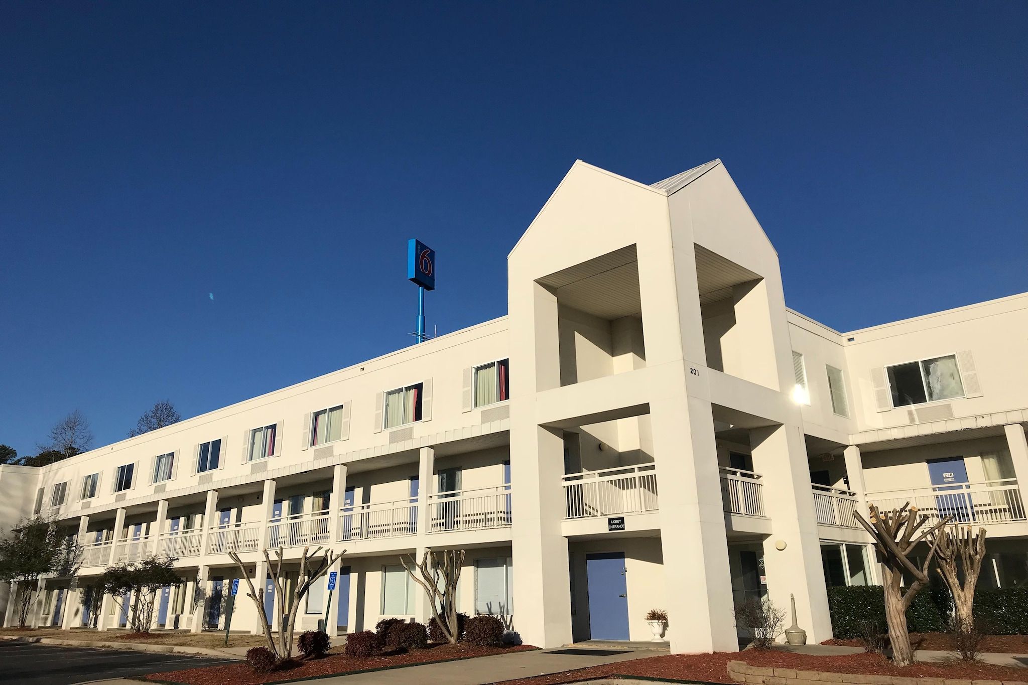 A multi-story hotel with a flat facade, balconies, and a flag.