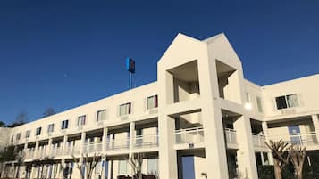 A multi-story hotel with a flat facade, balconies, and a flag.