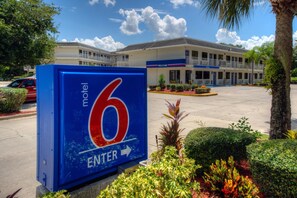 A motel sign with a large number 6 and an arrow pointing right, indicating the entrance direction. - Comfort 2 Full Beds | Mini Fridge (Bradenton)