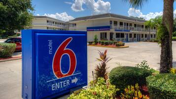 A motel sign with a large number 6 and an arrow pointing right, indicating the entrance direction.