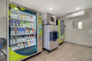 Ein Getränkeautomat mit verschiedenen Getränken und einem Wasserausgabeautomat in einem gewerblichen Bereich.