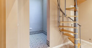 A spiral staircase with a metal railing and wooden steps, leading to an upper floor. - South Kensington Base Near Knightsbridge (London)
