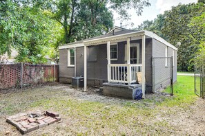 A small, single-story house with a porch, a fenced yard, and a brick fire pit. - Quiet Cul-De-Sac Near Fort Benning, Columbus (Columbus)