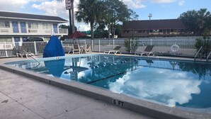 Una piscina amb un trampolí i gandules.