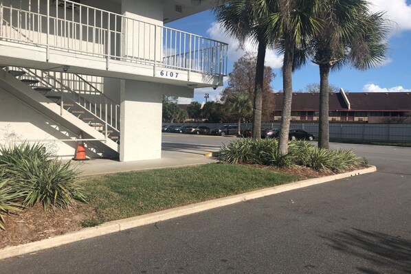 A building with a white exterior, a balcony, and a staircase leading to an upper level. - Sunny 2-Bed Room|Pool|Free Wifi (Jacksonville)