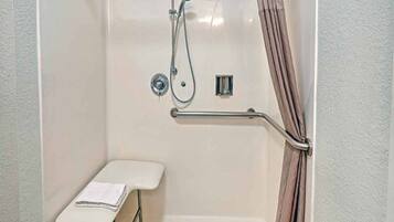 A bathroom with a shower, grab bar, and a small bench.