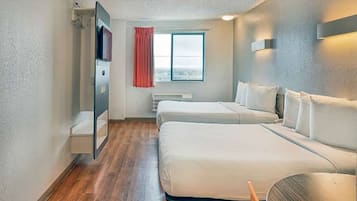 A hotel room with two beds, a window with curtains, a flat-screen TV, and a wall-mounted light fixture.