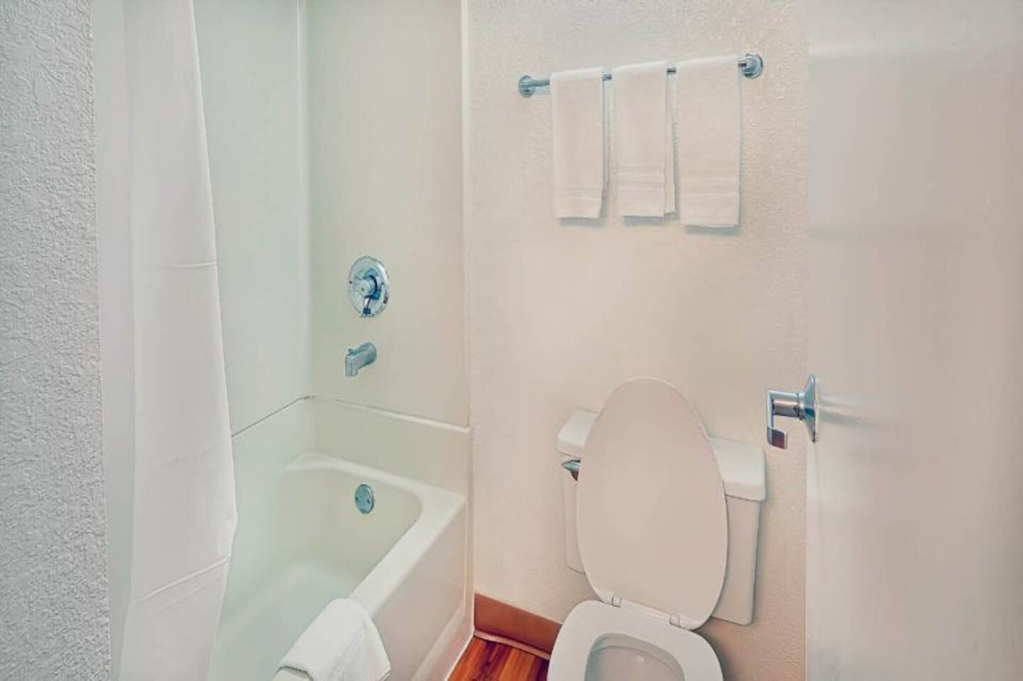 Une salle de bain avec une baignoire, des toilettes et un porte-serviettes.