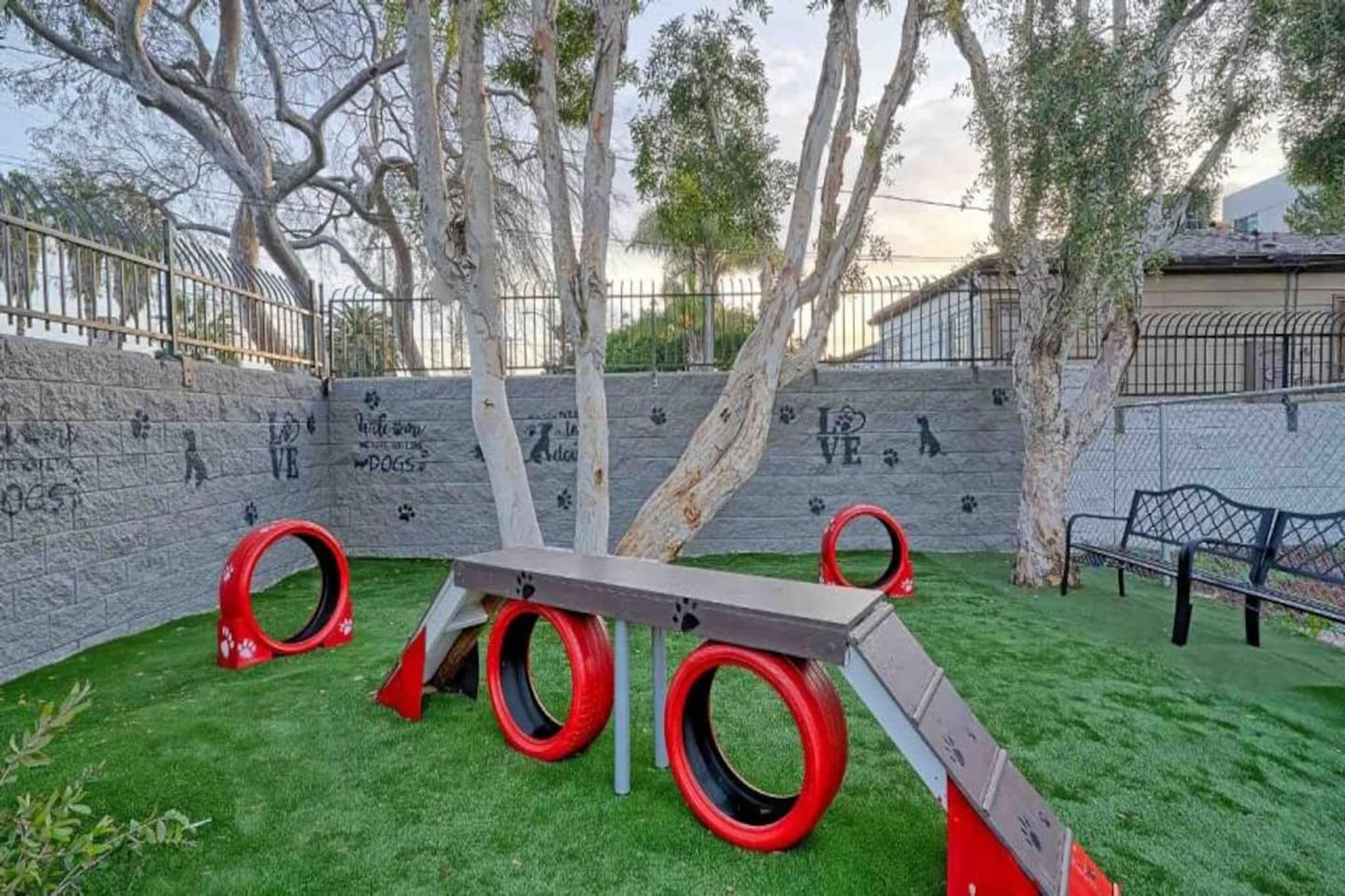 A playground with a slide, tire swings, and a bench.