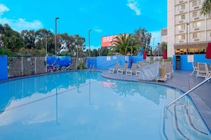 A swimming pool with lounge chairs and umbrellas, surrounded by a fence and trees. - 2 Queen Beds|Mini Fridge (Inglewood)