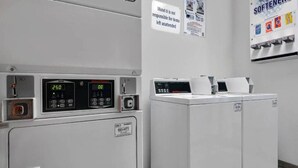 A laundry area with two washing machines, a control panel, and a sign indicating the motel's policy on unattended items. - 1 King Bed|Extended Suite (Cutler Bay)