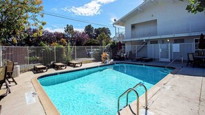 A rectangular swimming pool with a metal ladder, surrounded by a white fence. - 1 Queen Bed | Prescott (Prescott)