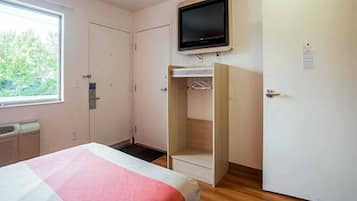 Ein Schlafzimmer mit Bett, Kleiderschrank, Fernseher und Fenster.