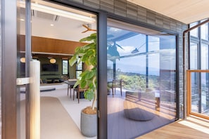 A modern interior with a dining area, a large potted plant, and a view through a glass door. - GLAMDAY ATAMI (Atami)