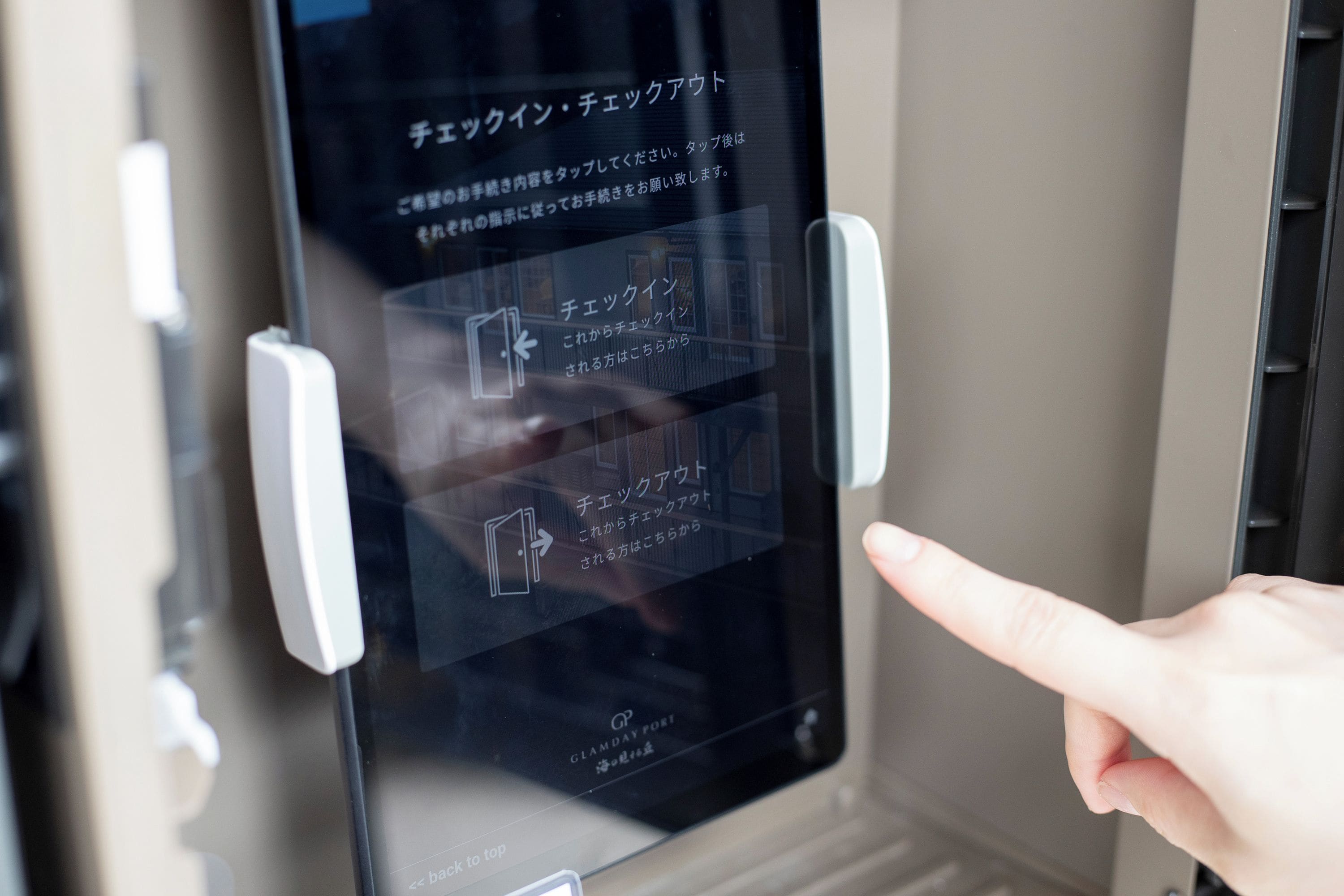 Interfaz digital en una puerta con instrucciones en japonés, incluyendo una opción para volver al inicio.