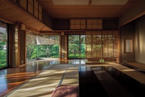 A traditional Japanese room with tatami flooring, sliding doors, and a view of a garden. - GLAMDAY ATAMI (Atami)