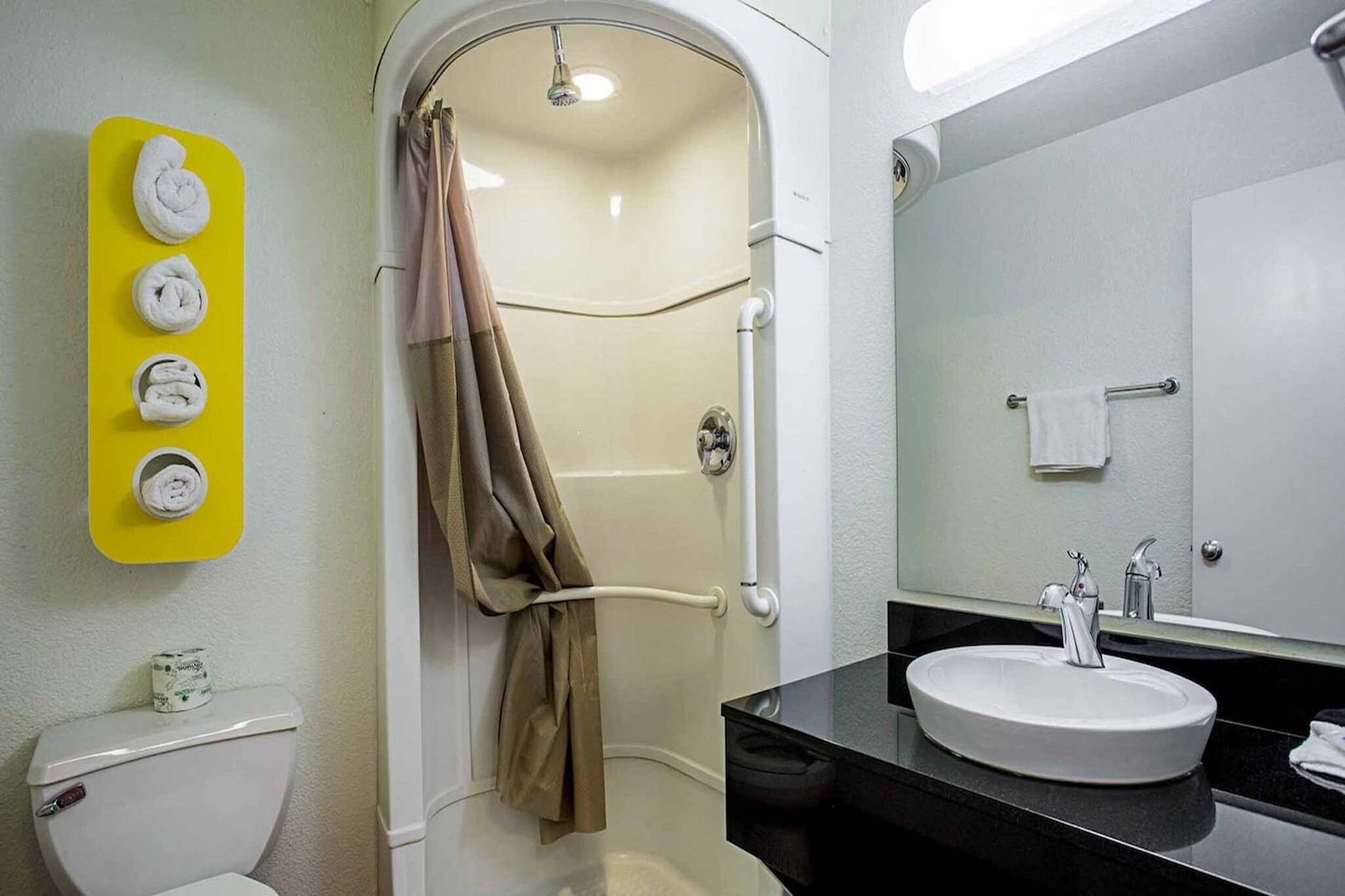 Une salle de bain équipée d’une douche, de toilettes, d’un lavabo et d’un porte-serviettes.