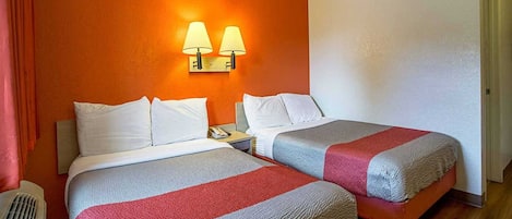 A hotel room with two beds, a nightstand, a telephone, and two wall-mounted lamps.