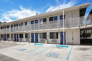 A motel with multiple rooms, a parking area, and a covered walkway.