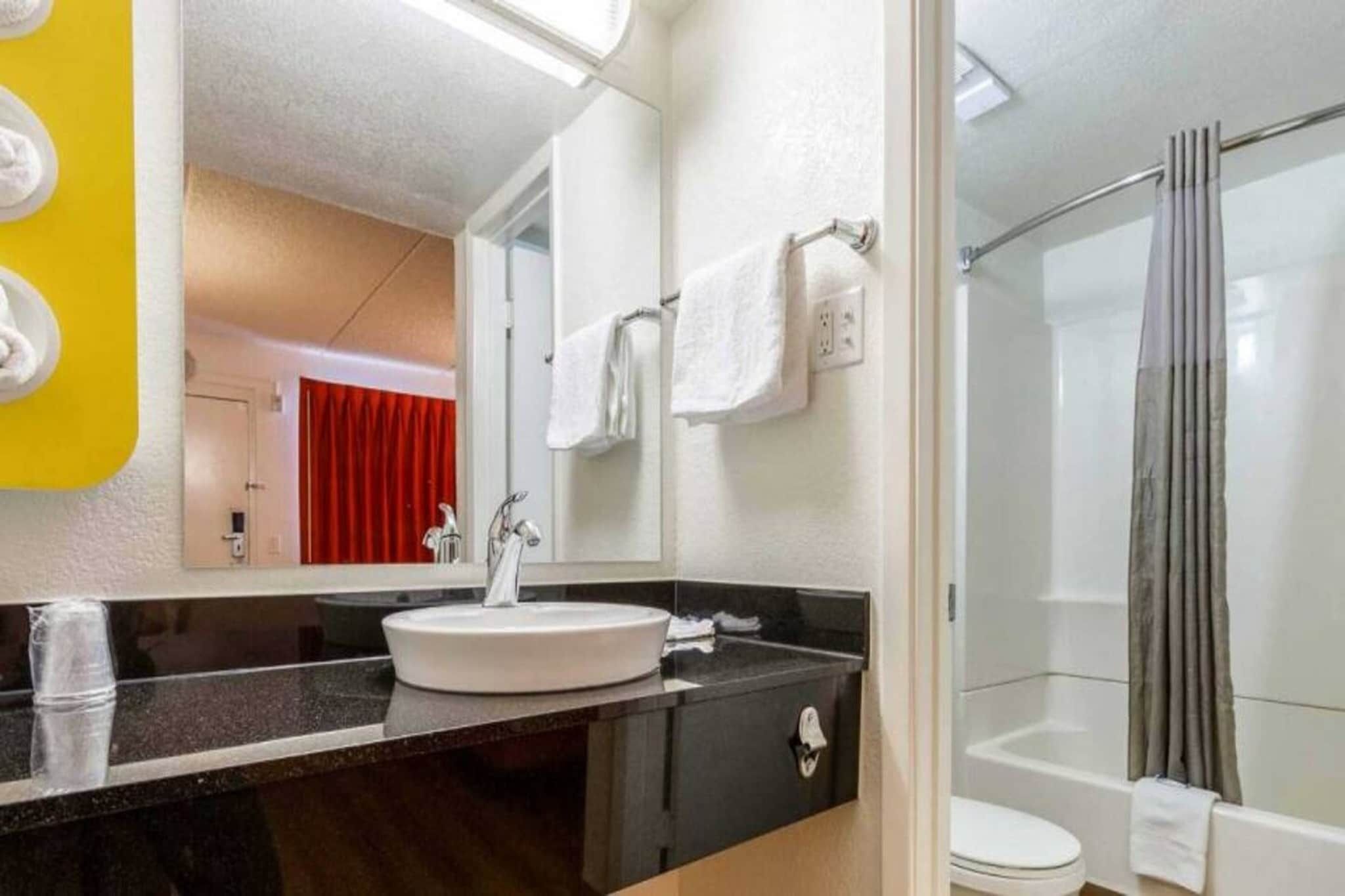 Une salle de bain avec un lavabo, un miroir et une douche.