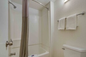 Une salle de bain avec une douche, des toilettes et un porte-serviettes.
