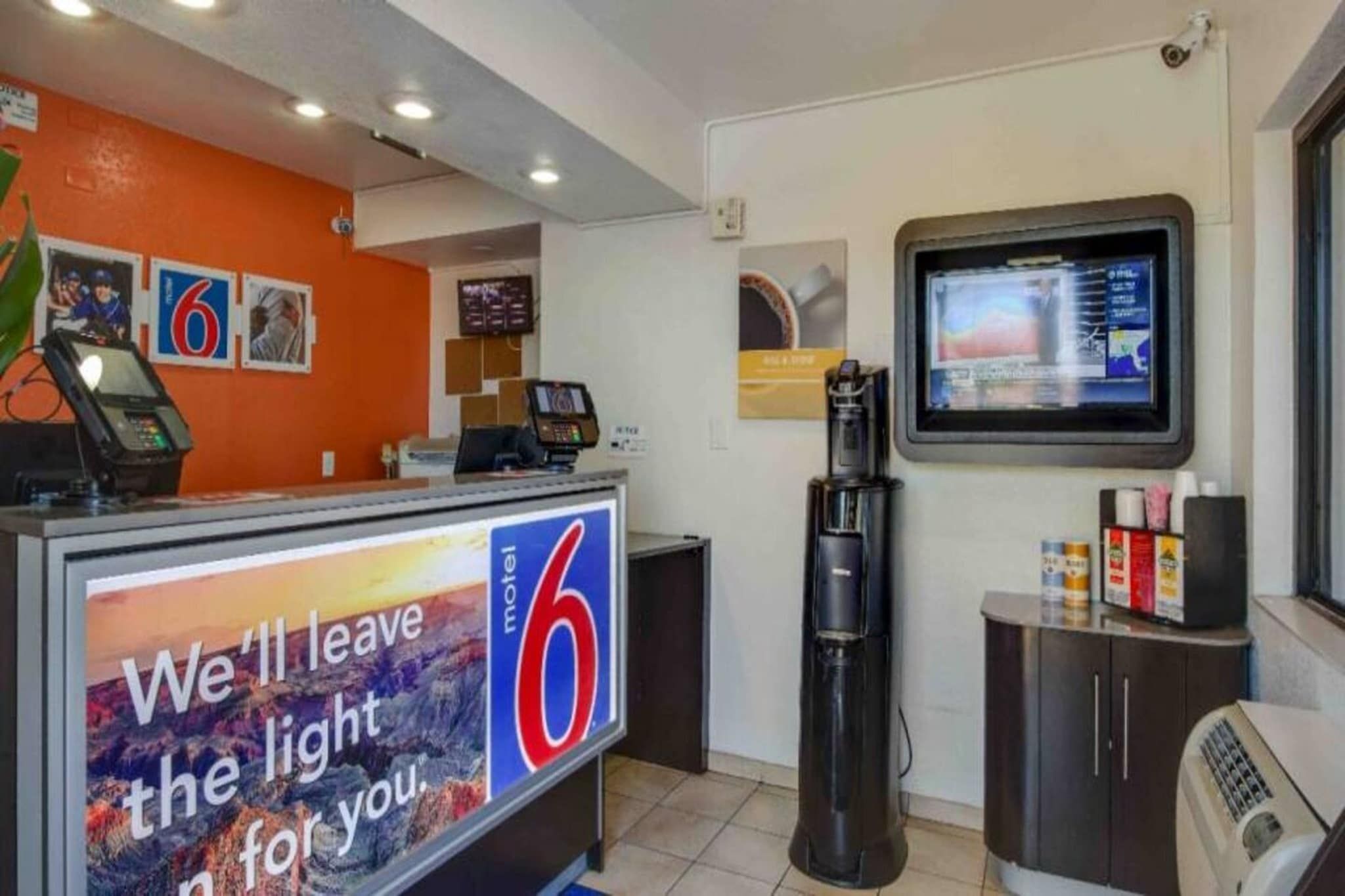 A motel reception desk with a large sign reading 'We'll leave the light for you.'