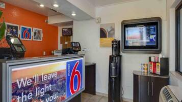 A motel reception desk with a large sign reading 'We'll leave the light for you.'