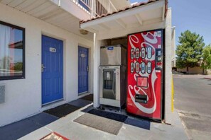 A building with two blue doors, a Coca-Cola vending machine, and a small refrigerator. - 1 Full Bed | ADA/RI Shower (Tempe)