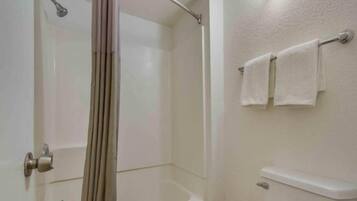 Ein Badezimmer mit Dusche, Toilette und Handtuchhalter.
