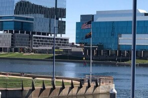 Vista al agua con edificios modernos, una bandera y una masa de agua.