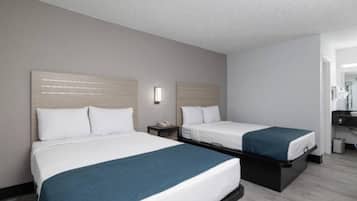 Ein Hotelzimmer mit zwei Betten, einem Nachttisch und einem Spiegel.