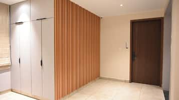 Une pièce dotée d’une armoire, d’un mur recouvert de panneaux en bois, d’une porte et d’un revêtement de sol carrelé.