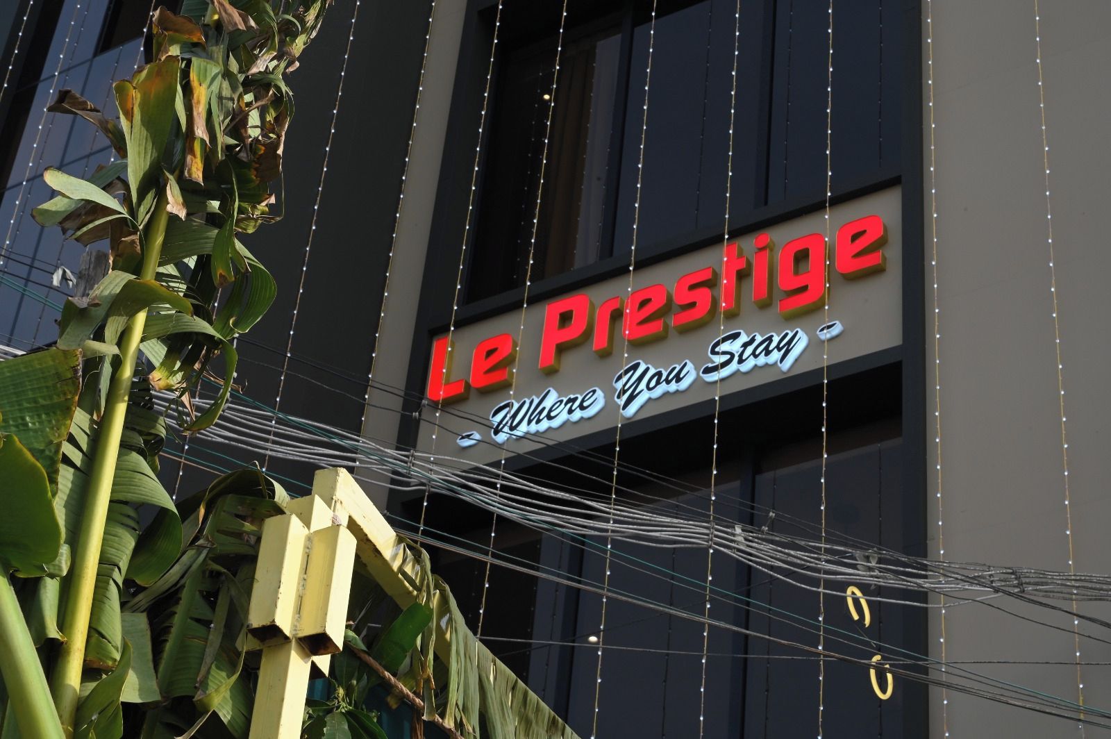 Un letrero de hotel con el nombre 'Le Prestige' y el eslogan 'Donde Te Hospedas'.