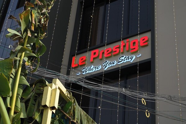 A hotel sign with the name 'Le Prestige' and the tagline 'Where You Stay'.