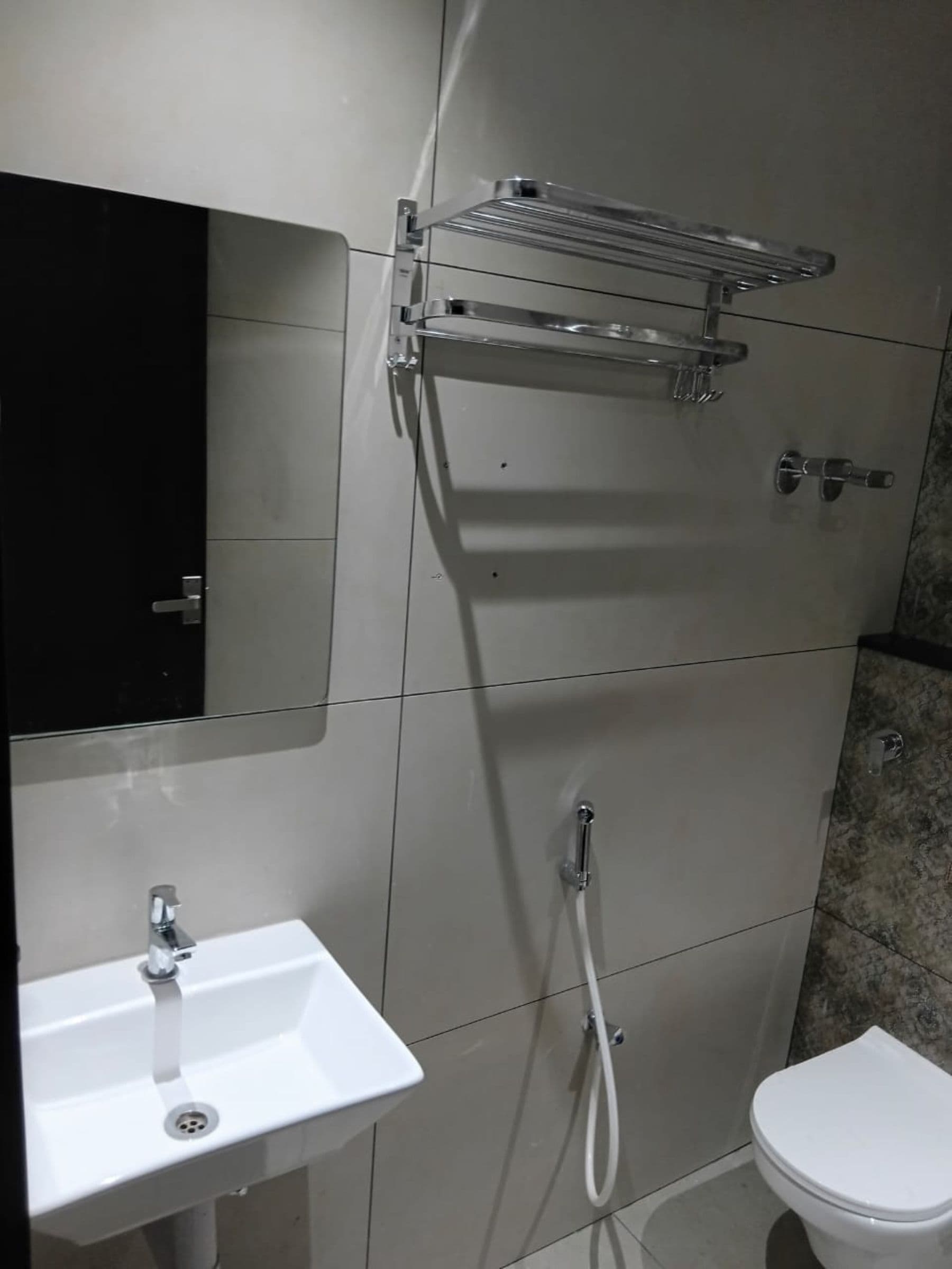 A bathroom with a white sink, a toilet, and a shower area.