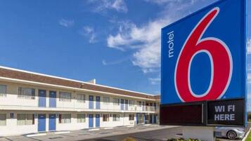 A motel with a large sign displaying the number 6 and a sign indicating WiFi availability.