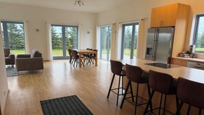 Eine moderne Küche mit einer großen Kochinsel, Barhocker und einem Essbereich mit Tisch und Stühlen.