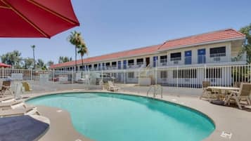 Ein Hotel mit Pool, Außenbereich und einem eingezäunten Bereich.